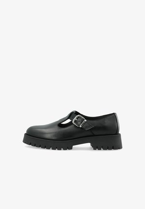 Black leather Mary Jane shoe with a silver buckle strap and a thick, treaded sole, shown from the side on a white background.