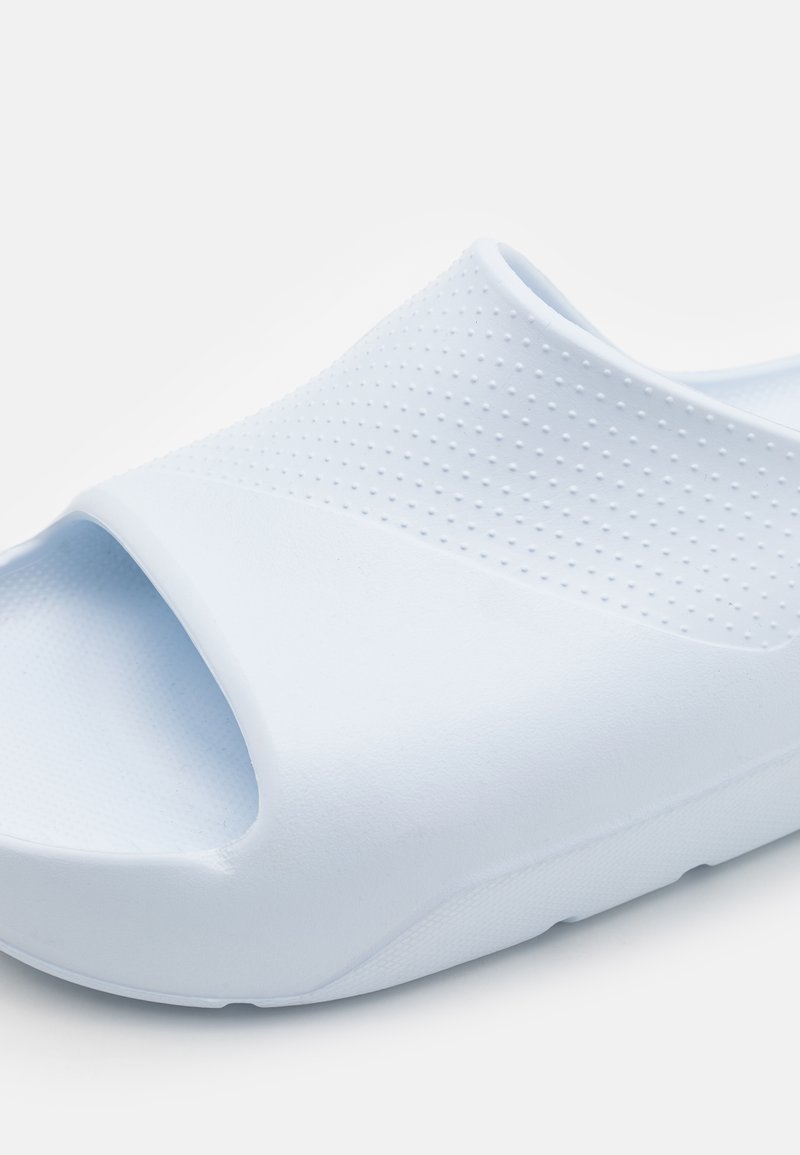 Sandale à glissière bleu clair avec une finition lisse et mate, dotée d'un dessus perforé pour la ventilation et d'une semelle rembourrée pour le confort.
