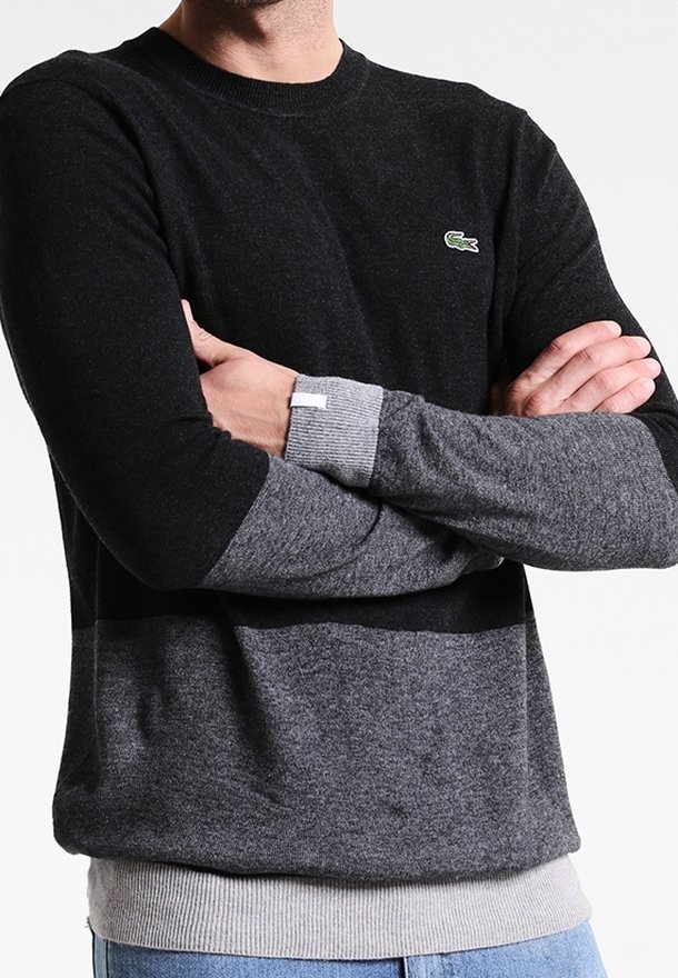 Svart och grå blockfärgad crew-neck tröja gjord av mjuk tyg med ribbade manschetter och nederkant, med en liten logotyp på bröstet.