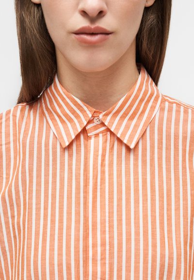 Πουκάμισο με γιακά σε ανοιχτό πορτοκαλί χρώμα με λευκές κάθετες ρίγες, διαθέτει κλείσιμο με κουμπιά και μαλακό, υφή ύφασμα.