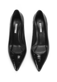 Escarpins en cuir verni noir avec un bout pointu, présentant un motif crocodile texturé et une doublure intérieure lisse.
