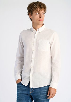 Witte lange mouwen shirt gemaakt van lichtgewicht stof, met een knoopsluiting kraag en een enkele borstzak, gecombineerd met blauwe jeans.