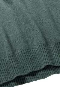 Dunkelgrüner Strickpullover mit geripptem Saum. Weiche Textur, mit vertikalen Streifen und lockerer Passform. Der Stoff wirkt warm und gemütlich.