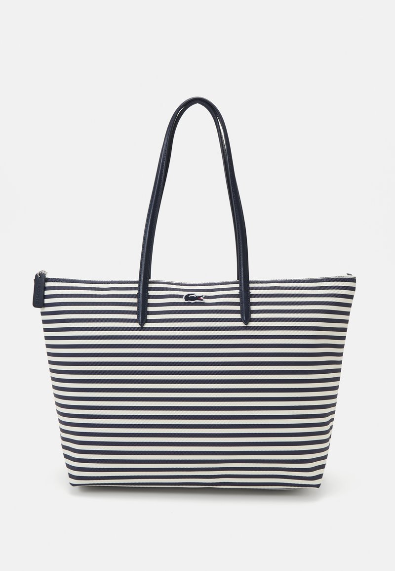Sac fourre-tout rayé avec des rayures horizontales bleu marine et blanches, en matériau durable, doté de longues poignées et d'une fermeture éclair.
