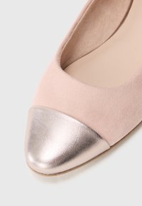 Ροζ σουέτ επίπεδα παπούτσια με λαμπερή μεταλλική ροζ χρυσή μύτη. Το παπούτσι διαθέτει μαλακή εσωτερική επένδυση και στρογγυλεμένη μορφή.