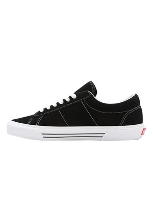 Sneaker nera in suede con lacci bianchi, suola bianca e dettagli minimalisti in bianco e nero. Caratterizza cuciture decorative.