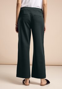 Pantaloni a gamba larga in tessuto verde scuro con vita elastica, due tasche posteriori e una texture liscia e morbida.
