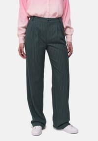 Donkergroene gestreepte broek met een relaxte pasvorm, met een vlakke voorkant, zijzakken en gecombineerd met witte sneakers.