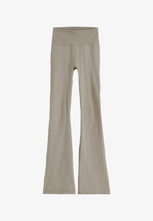 Pantalones de tela beige acanalada con cintura alta y piernas acampanadas, diseñados para uso casual o para estar en casa.