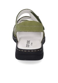 Grüne Wildledersandale mit mehreren gekreuzten Riemen, weißer Lederinnensohle, schwarzer Gummisohle und kontrastierenden Nähdetails.