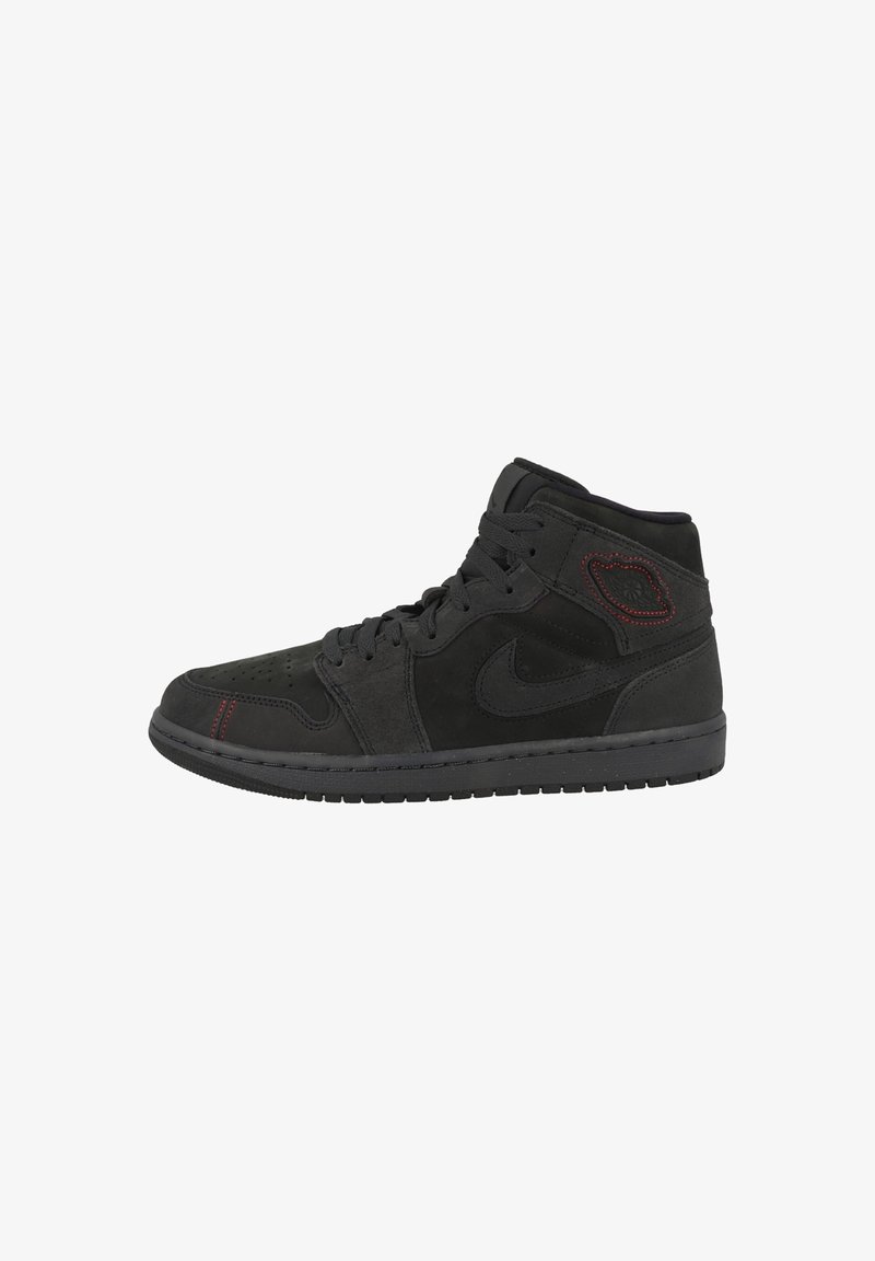 Baskets montantes noires avec lacets à l'avant, logo Nike sur le côté et détails de coutures rouges près de la cheville et des orteils.