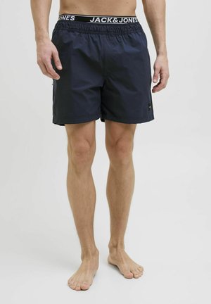 Bañadores navy con cintura elástica que presentan el texto "JACK & JONES". Material suave y ligero, con bolsillos laterales y un corte clásico.
