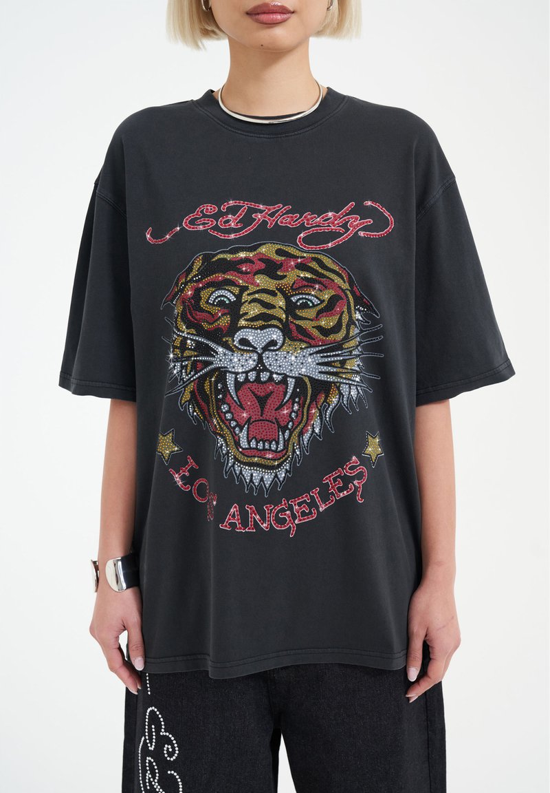 Svart grafisk t-shirt med en färgglad tigerdesign prydd med rhinestones, "Ed Hardy"-logotyp och texten "Los Angeles" i röd.