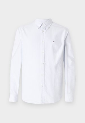 Camisa abotonada de rayas azul claro y blanca con mangas largas, cuello con solapa y detalle de logo en el pecho. Fabricada con una tela suave.