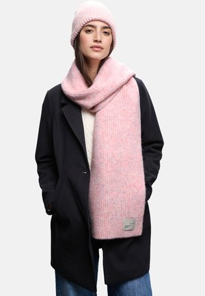 Beanie a coste rosa e sciarpa coordinata esposte, entrambe caratterizzate da una consistenza morbida e un delicato motivo marmorizzato, con un'etichetta in tessuto sulla sciarpa.