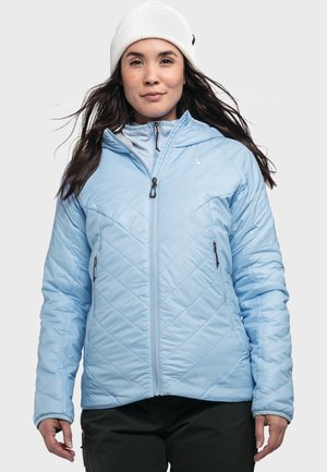 Hellblau gesteppte, isolierte Jacke mit Reißverschluss vorne, verstellbare Kapuze und zwei seitlichen Reißverschlusstaschen. Gerippte weiße Mütze, die auf dem Kopf getragen wird.