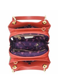 Rote Lederhandtasche mit strukturiertem Finish, ausgestattet mit goldenen Beschlägen, mehreren Fächern und einem dunkelvioletten Innenraum mit floralem Muster.