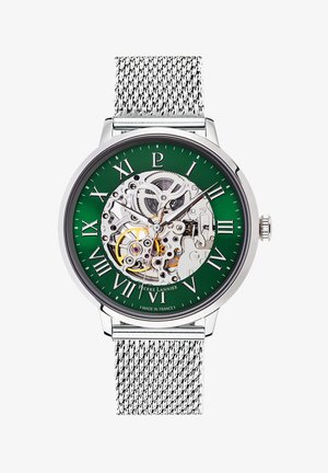 Skeleton horloge met een groene wijzerplaat, zilveren uurmarkeringen en een stainless steel mesh band; bevat transparante details van de mechanische beweging.