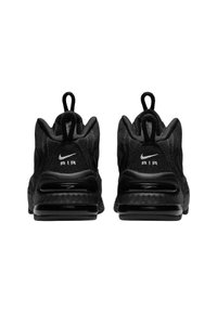 Une paire de baskets Nike Air noires vue de l'arrière, présentant des languettes de tirage et un amorti à air visible dans les semelles.
