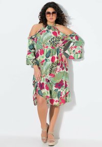 Vestido con estampado floral y de animales, diseño de hombros al aire, mangas con volantes y cinturilla ajustada; presenta verdes, rosas y azules vibrantes.