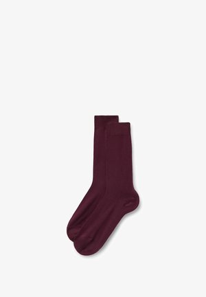 Ein Paar schlichte, dunkelburgunderfarbene Socken in mittlerer Wadenhöhe mit Rippbündchen, flach auf einem weißen Hintergrund liegend.
