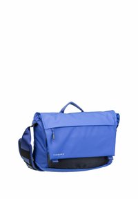 Blaue Timbuk2 Messenger-Tasche mit verstellbarem Schultergurt, vorderer Reißverschlusstasche und gepolsterter Klappenverschluss.