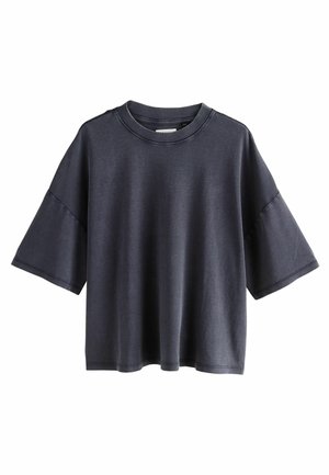 Tamsiai pilkas per didelis marškinėliai su trumpomis rankovėmis, apvaliu iškirpimu ir glotnia medvilnės tekstūra. Minimalistinis dizainas, jokių raštų ar akcentų.