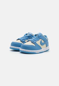 Niebieskie skórzane sneakersy z kremowymi akcentami, wyściełanym kołnierzem, perforowanym czubkiem i białą podeszwą środkową. Posiadają niebieskie sznurowadła i logo z boku.
