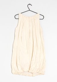 Sleeveless, cream-colored dress with pleated design; soft, textured fabric; gathered hem at the bottom; hangs from a black hanger.