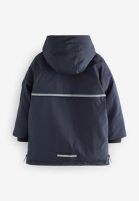 Chaqueta impermeable azul marino con capucha, que cuenta con una franja reflectante en la parte posterior, bolsillos con cremallera y un acabado texturizado.