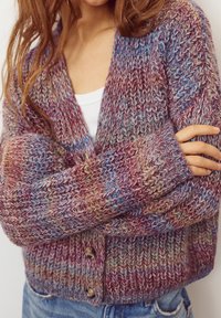 Cardigan tricotat cu un model multicolor în nuanțe de violet, albastru și bej. Are închidere cu nasturi și o croială lejeră, confortabilă.