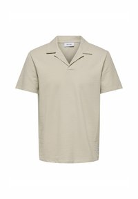 Polo a maniche corte, di un beige chiaro, con tessuto testurizzato, dotato di colletto a scollo a V e orlo dritto, pratico per un abbigliamento casual.