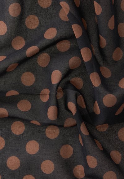 Tissu noir avec un motif uniformément espacé de gros pois marron, présenté avec des plis doux et des détails de texture.