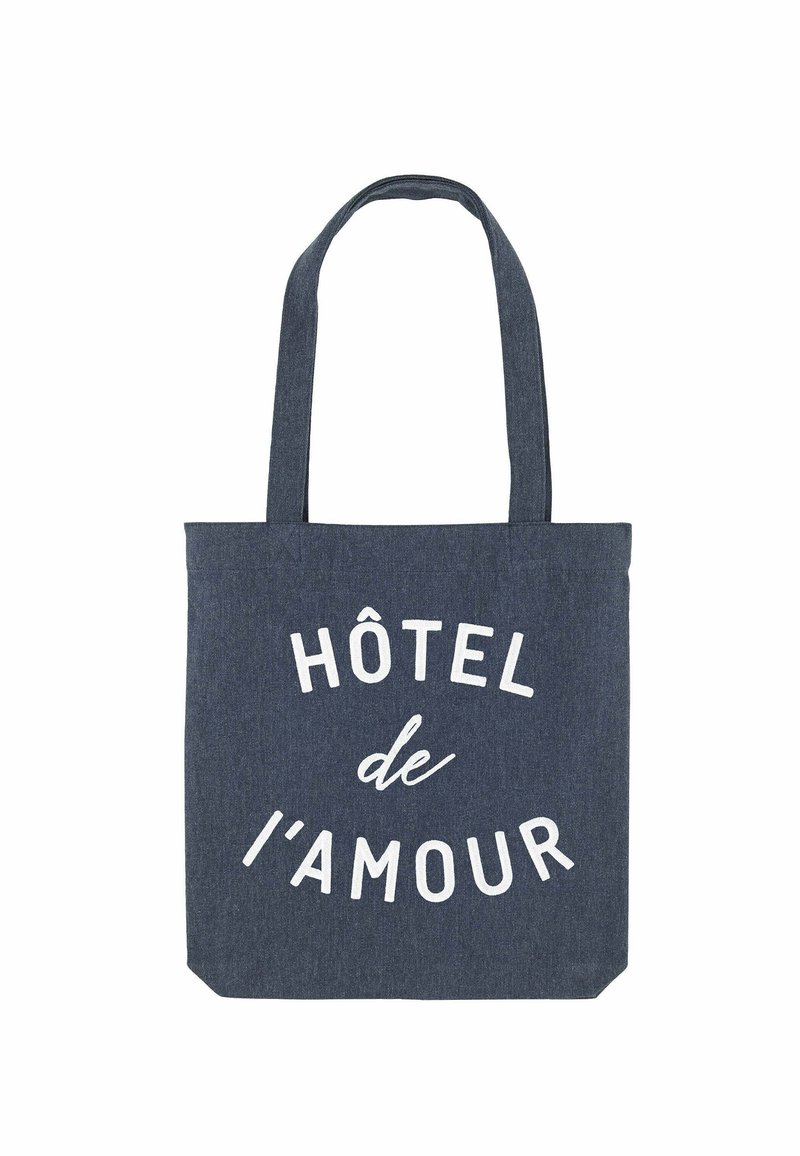 Borsa a tracolla in denim blu con testo bianco che recita "HÔTEL de l'amour", dotata di due manici resistenti e di forma rettangolare.