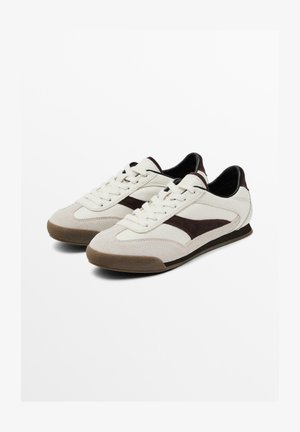 Jasnokremowe sneakersy z brązowymi zamszowymi akcentami, sznurowany design, teksturowany przód i gumowa podeszwa dla lepszej przyczepności. Smukły profil i minimalistyczne detale.