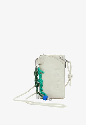 Világos bézs műbőr keresztpántos telefontartó dombornyomott logóval, zöld fonott pánttal, türkiz részletekkel és ezüst színű fém kiegészítőkkel.