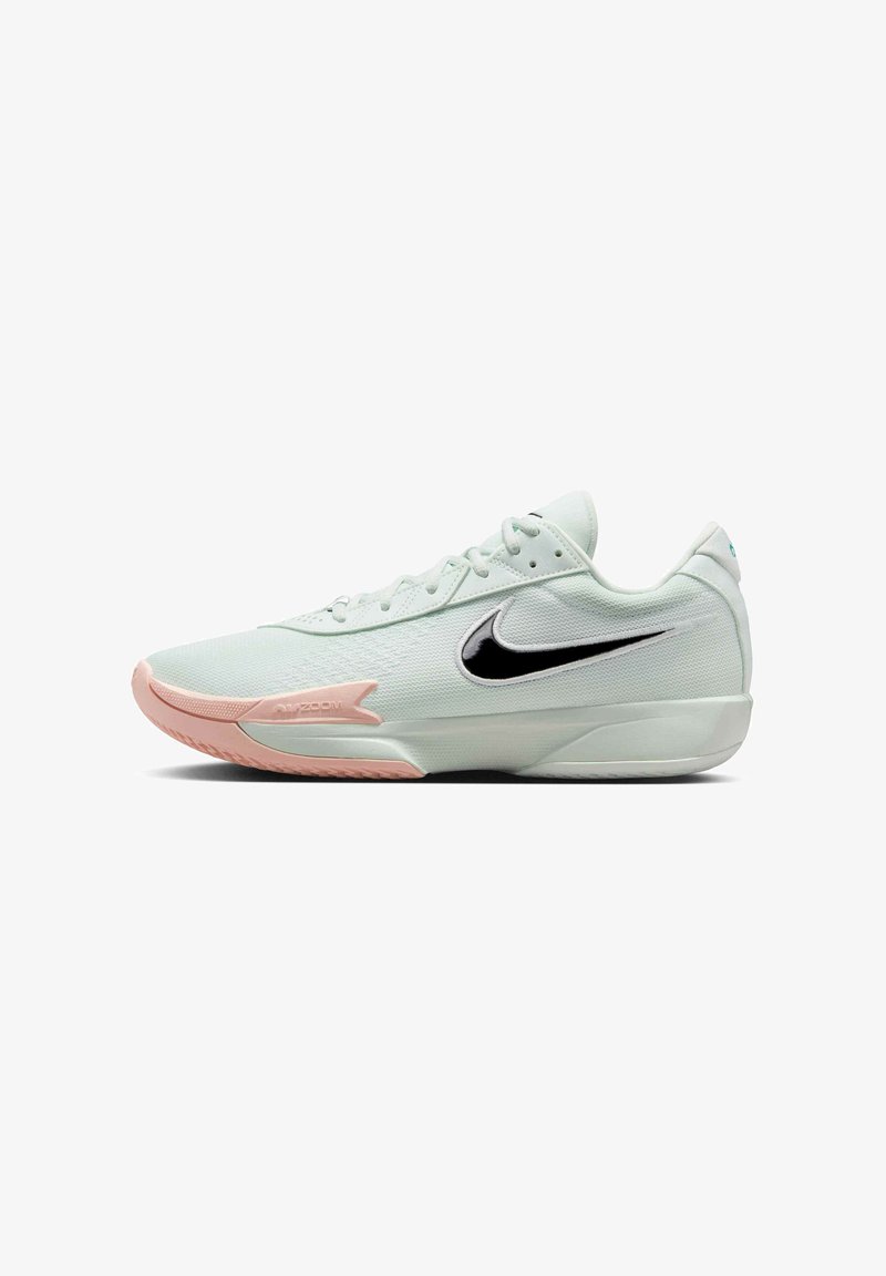 Baskets de sport vert clair avec une tige texturée, logo swoosh noir, semelle rose et design à lacets. Présente un détail "Air Zoom" sur le côté.