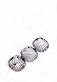Accessorio in metallo argentato a tre parti con una texture rigata e forma quadrata arrotondata. Presenta un connettore centrale. Superficie riflettente.