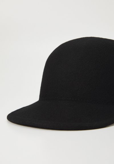Gorro de fieltro negro con una parte superior redondeada y una visera ancha y plana. Presenta una textura suave y un sutil trabajo de costura a lo largo de las costuras.