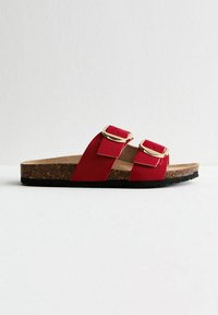 Sandal rossa a due cinghie con plantare in sughero, suola in gomma testurizzata e dettagli in metallo dorato sulle cinghie.