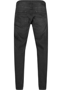 Jeans de mezclilla negra con corte slim, dos bolsillos traseros y una textura suave. Presentan una cintura de altura media y detalles de diseño mínimos.