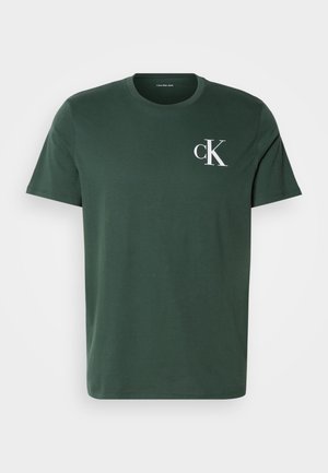 Zeleni pamučni majica s kratkim rukavima, okruglim izrezom i bijelim "ck" logom na lijevoj strani prsnog koša. Glatka tekstura i ležeran kroj.