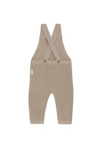Beige gebreide babyoverall met gekruiste schouderbanden en twee knopen aan de voorkant, met een wafelstructuur en geribde manchetten.