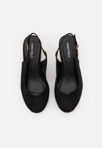 Čierne semišové slingback topánky s špicatou špičkou, s textúrovanou podrážkou a jemným povrchom. Logo "ANNA FIELD" je viditeľné na vnútornej podrážke.