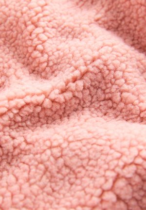 Puha rózsaszín polár anyag texturált, bolyhos felülettel, amely kiemelkedő, lekerekített szálakat tartalmaz, meleg és otthonos megjelenést kölcsönözve.
