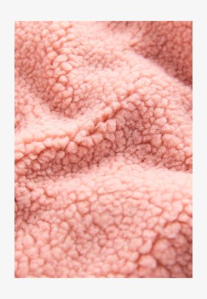 Tessuto in pile rosa tenue con una superficie testurizzata e soffice, caratterizzata da fibre arrotondate e rialzate, che crea un aspetto caldo e accogliente.