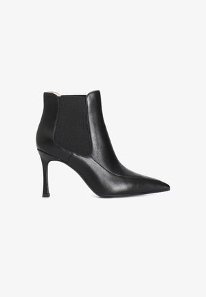 Schwarze Leder-Stiefelette mit spitzem Fuß, elastischen Seitenpanelen und einem Stiletto-Absatz. Glatte Textur und minimalistisches Design.