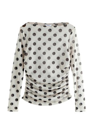Langærmet top i transparent stof med sorte prikker på en lys baggrund, der har et sammensnøret design ved taljen.