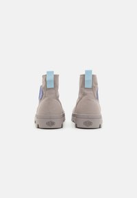 Et par beige kanvas ankelstøvler med lyseblå trækstropper og gummisåler, set fra bagpå mod en hvid baggrund.