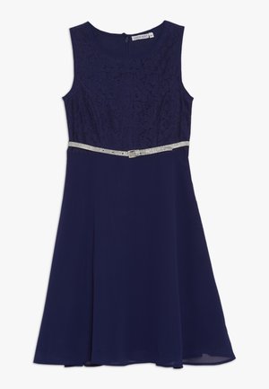 Mouwloze marineblauwe jurk met kanten lijfje, ronde halslijn, vloeiende rok en zilveren glitterriem in de taille.